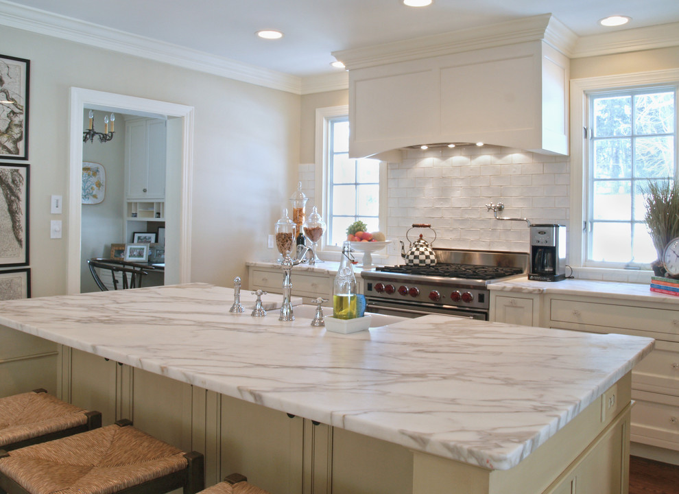 Eat-in kitchen - small transitional single-wall medium tone wood floor eat-in kitchen idea with a double-bowl sink, shaker cabinets, white cabinets, stainless steel appliances, an island, quartzite countertops, white backsplash and subway tile backsplash