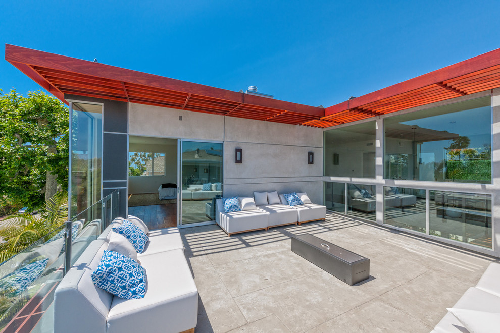 Photo of a mid-sized contemporary two-storey concrete grey exterior in Los Angeles with a flat roof.