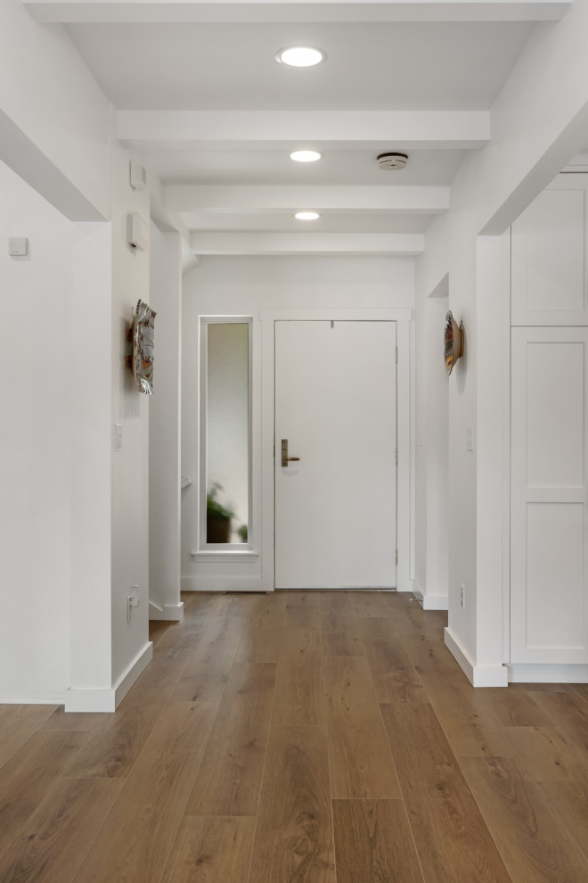 Inspiration for a mid-sized beach style front door in Seattle with vinyl floors, a single front door, a white front door, brown floor and coffered.