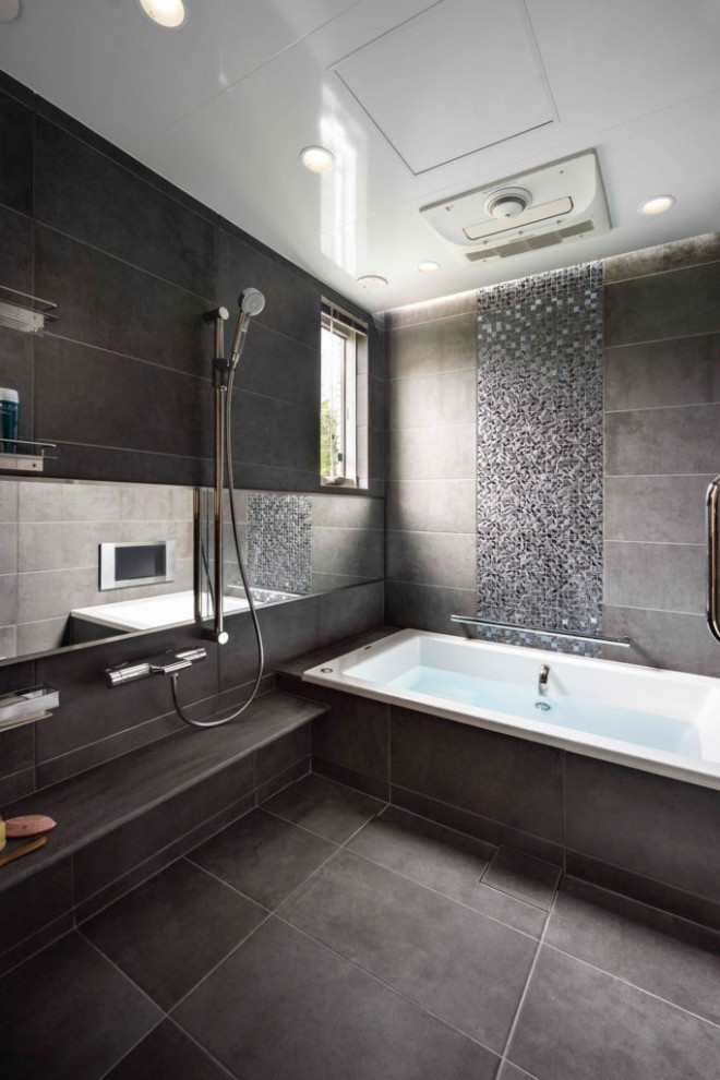 Imagen de cuarto de baño moderno con bañera encastrada, baldosas y/o azulejos negros, paredes negras, suelo negro y bandeja