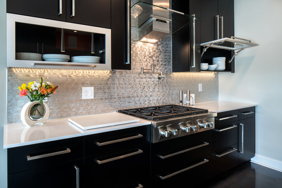 Design ideas for a large contemporary galley eat-in kitchen in Charlotte with an integrated sink, flat-panel cabinets, black cabinets, quartz benchtops, metallic splashback, metal splashback, stainless steel appliances, concrete floors, with island and grey floor.