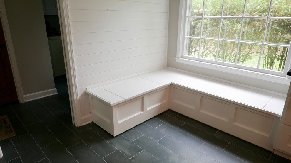 Inspiration for a mid-sized transitional galley porcelain tile and black floor eat-in kitchen remodel with a farmhouse sink, shaker cabinets, white cabinets, soapstone countertops, white backsplash, subway tile backsplash, white appliances, an island and black countertops