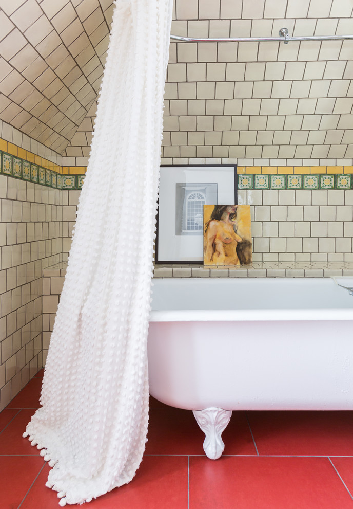 Photo of a mid-sized eclectic 3/4 bathroom in Houston with raised-panel cabinets, yellow cabinets, a freestanding tub, a shower/bathtub combo, beige tile, ceramic tile, white walls, porcelain floors, red floor and a shower curtain.