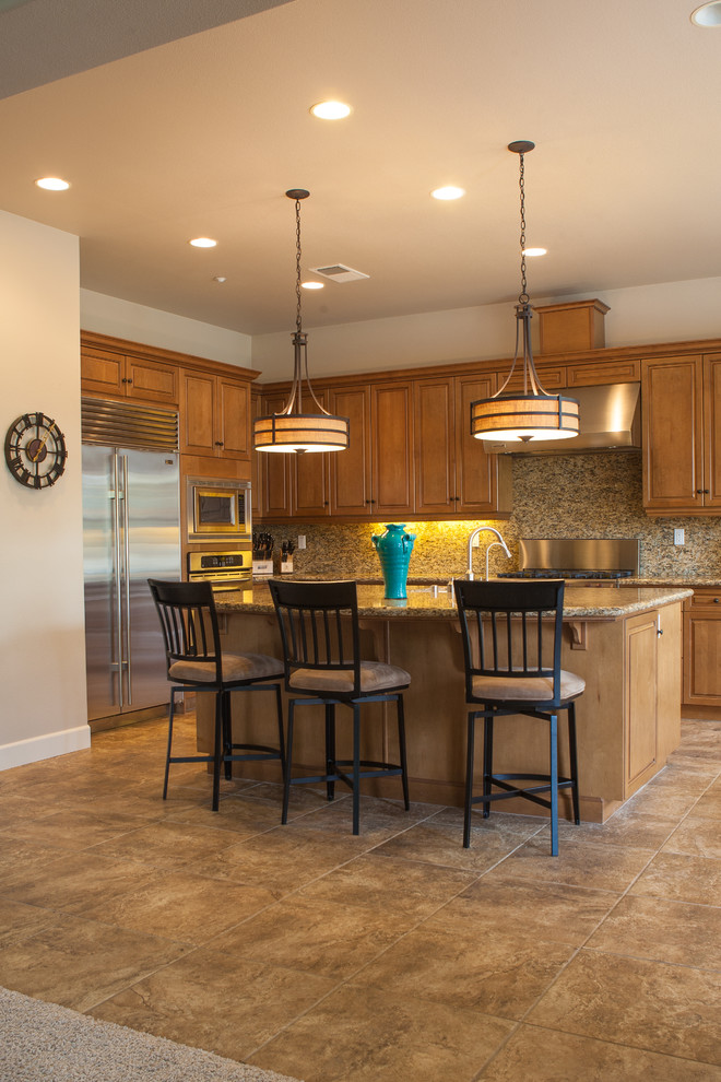 Inspiration for a mid-sized transitional galley porcelain tile and beige floor open concept kitchen remodel with an undermount sink, medium tone wood cabinets, granite countertops, stone slab backsplash, stainless steel appliances, an island, raised-panel cabinets and black backsplash
