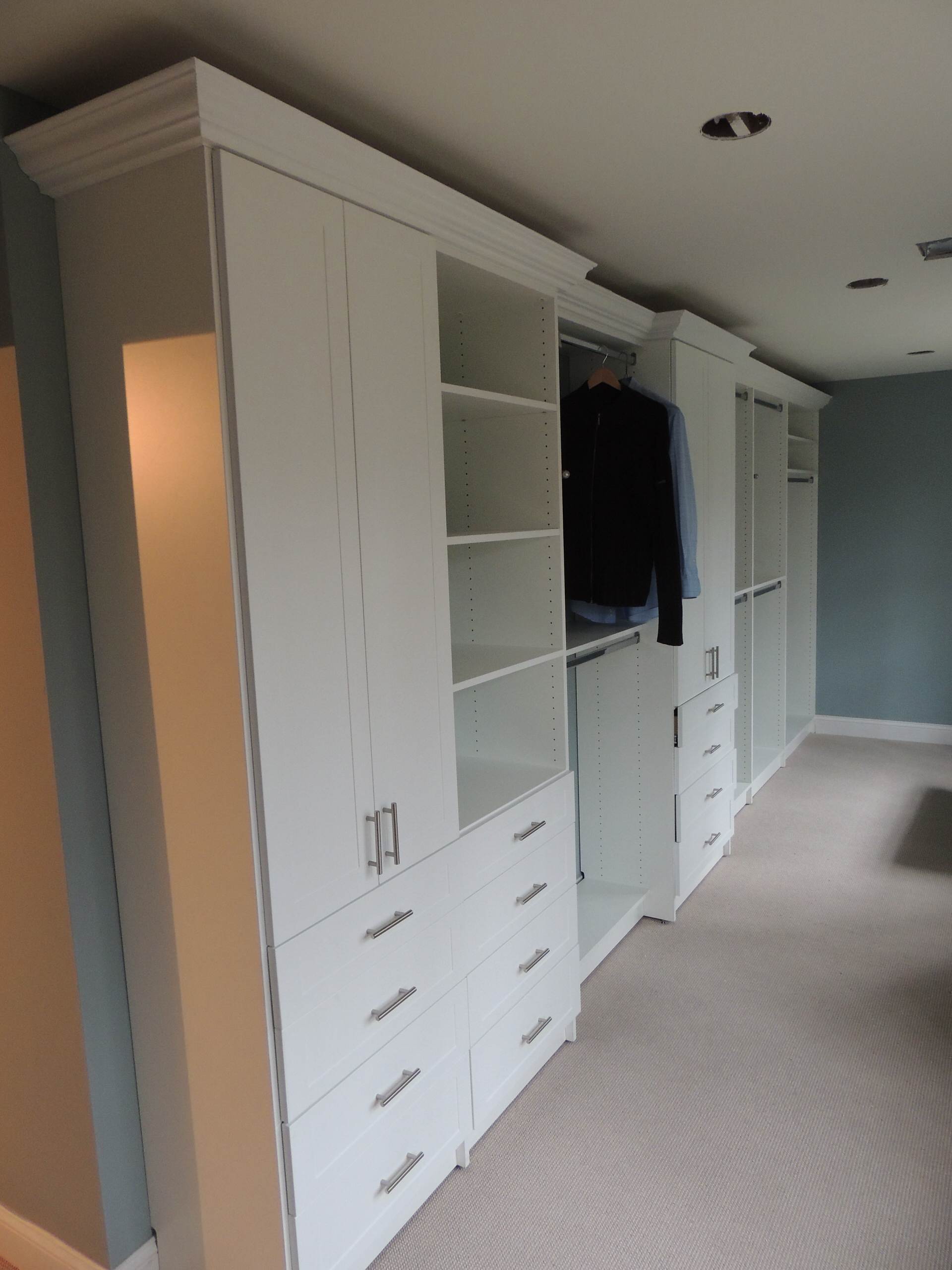 White cabinets with double doors and drawers, hang units, topped with crown molding