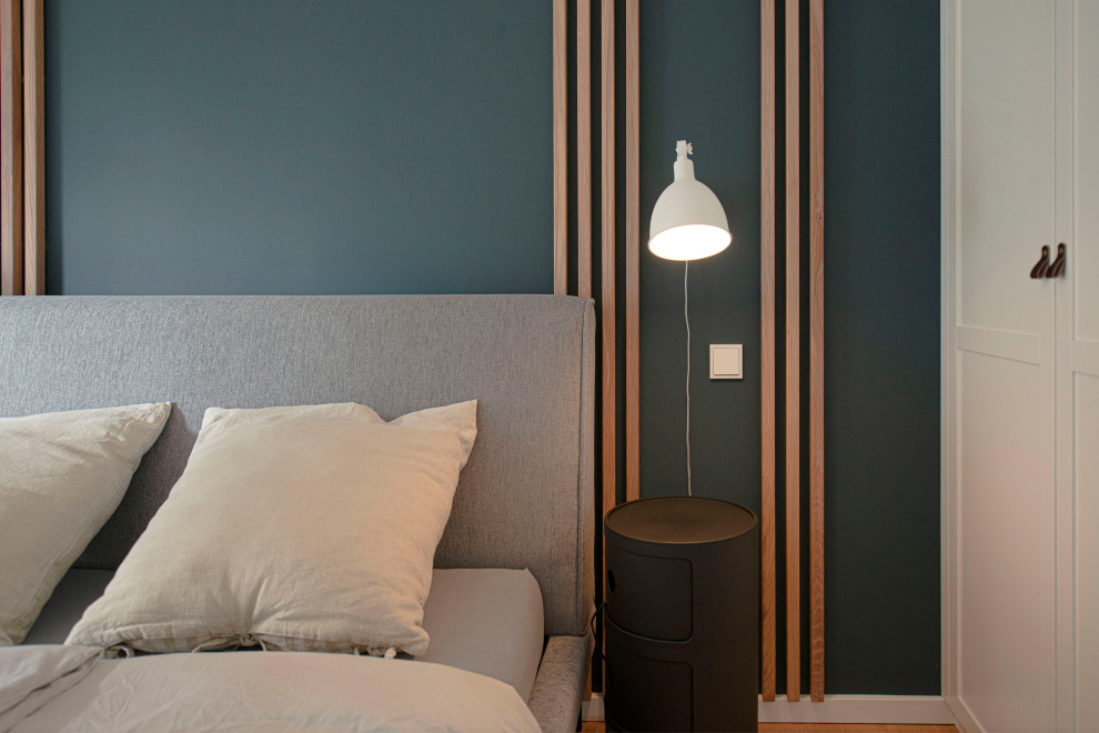 Esempio di una camera da letto design di medie dimensioni con pareti blu, pavimento in legno verniciato e pavimento marrone