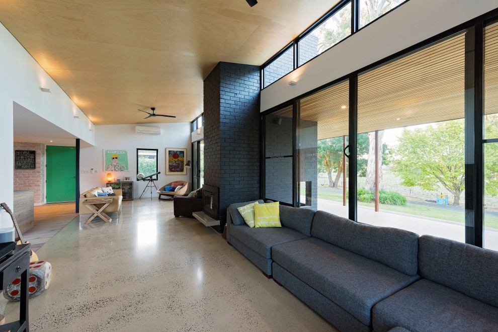 Inspiration for a mid-sized contemporary open concept concrete floor, gray floor, shiplap ceiling and brick wall living room remodel in Adelaide with white walls, a standard fireplace and a brick fireplace