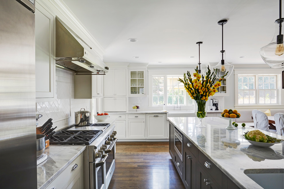 Large transitional galley eat-in kitchen in Chicago with recessed-panel cabinets, white cabinets, marble benchtops, white splashback, subway tile splashback, stainless steel appliances, dark hardwood floors, with island and an undermount sink.