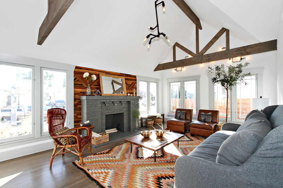 This is an example of a country living room in Los Angeles with white walls, medium hardwood floors, a standard fireplace, a brick fireplace surround and brown floor.