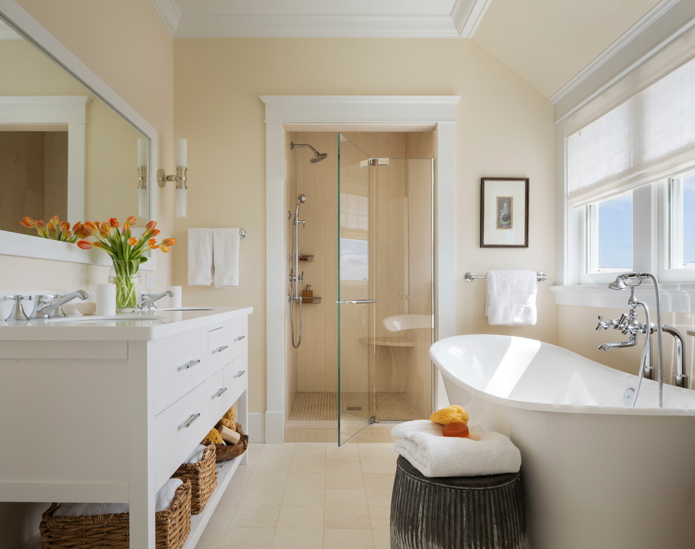 Mid-sized beach style master bathroom in New York with flat-panel cabinets, white cabinets, a freestanding tub, an alcove shower, beige walls, limestone floors, an undermount sink, quartzite benchtops, a hinged shower door, beige tile and beige floor.