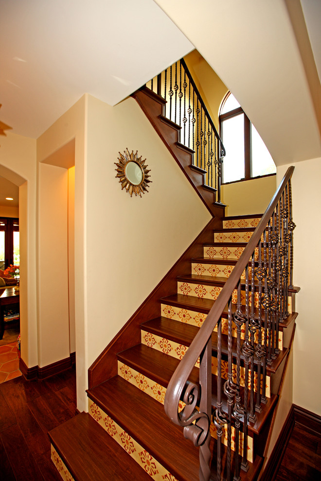This is an example of a mediterranean wood u-shaped staircase in Los Angeles with tile risers.