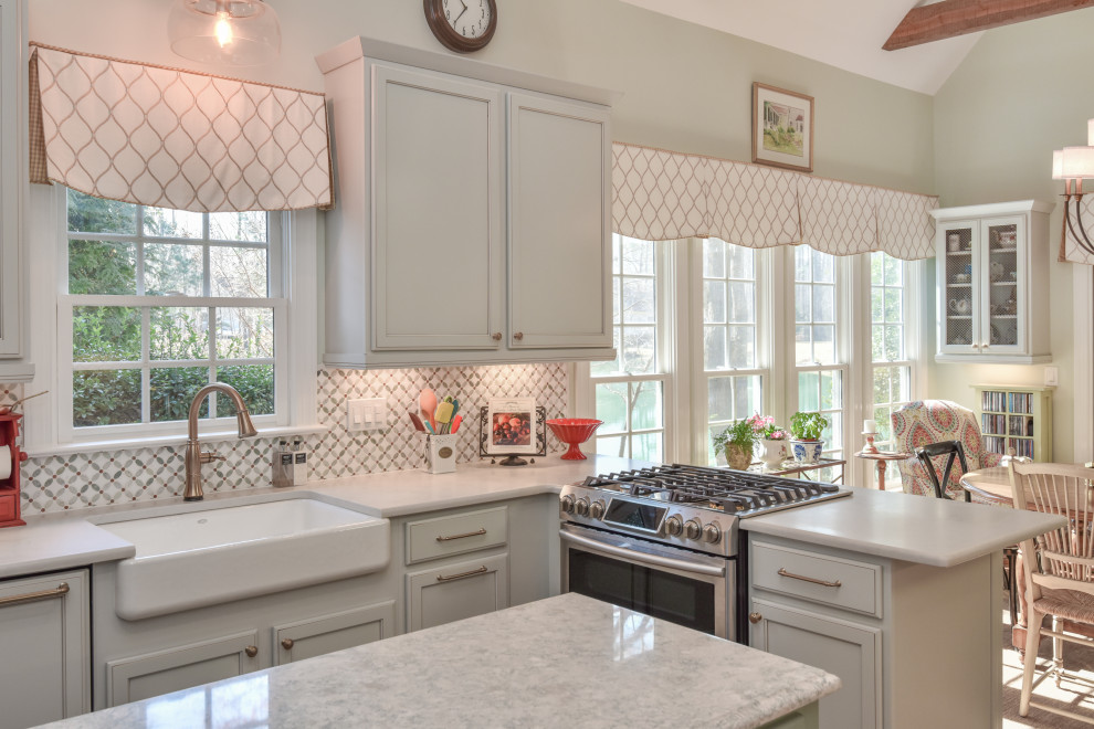 Example of a large transitional u-shaped kitchen design in DC Metro with a farmhouse sink, recessed-panel cabinets, quartz countertops, stainless steel appliances and an island