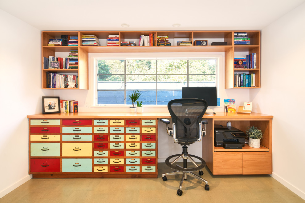 Mittelgroßes Industrial Arbeitszimmer mit weißer Wandfarbe, Korkboden, Einbau-Schreibtisch und grauem Boden in San Diego
