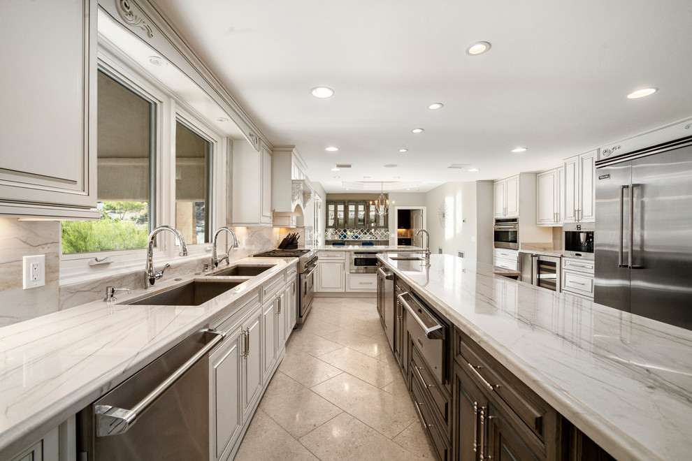 Eat-in kitchen - large transitional u-shaped porcelain tile and beige floor eat-in kitchen idea in Phoenix with an undermount sink, raised-panel cabinets, dark wood cabinets, quartzite countertops, white backsplash, stone slab backsplash, stainless steel appliances, an island and white countertops