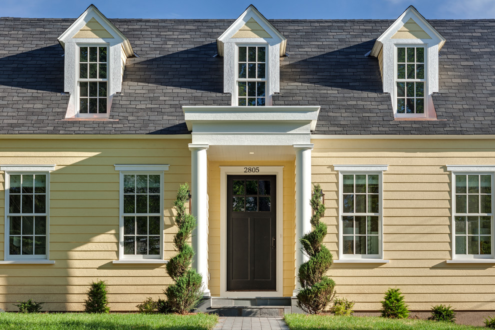 Large elegant yellow two-story wood exterior home photo in Minneapolis