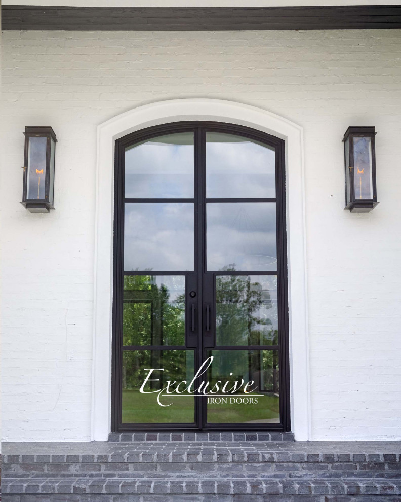Immagine di una porta d'ingresso minimalista di medie dimensioni con pareti bianche, una porta a due ante e una porta nera