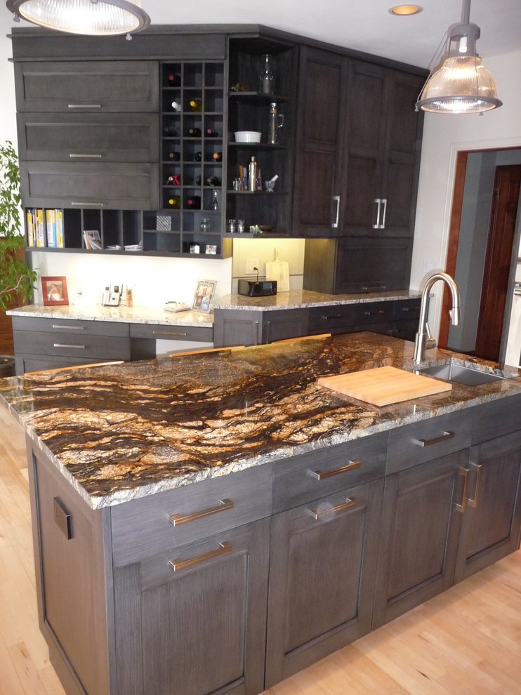 Large transitional u-shaped light wood floor eat-in kitchen photo in Milwaukee with an undermount sink, flat-panel cabinets, gray cabinets, granite countertops, white backsplash, porcelain backsplash, stainless steel appliances and an island