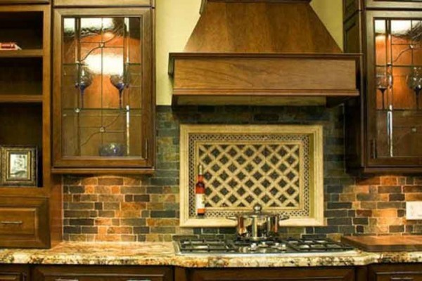 Open concept kitchen - mid-sized craftsman l-shaped open concept kitchen idea with a drop-in sink, glass-front cabinets, dark wood cabinets, multicolored backsplash and stainless steel appliances