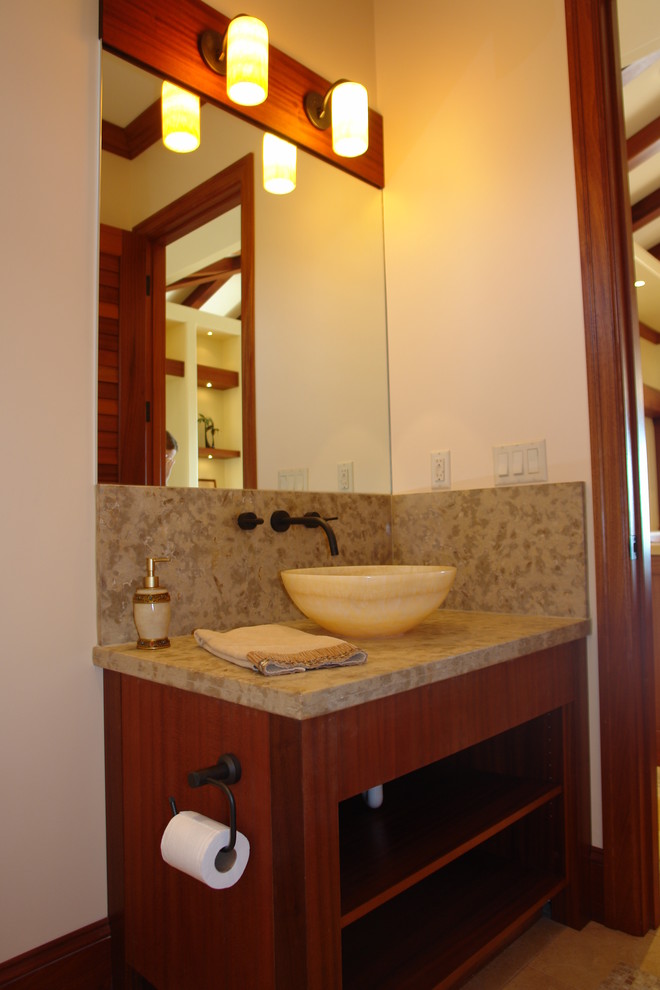 Photo of an expansive tropical 3/4 bathroom in San Francisco with shaker cabinets, dark wood cabinets, a one-piece toilet, beige walls, limestone floors, a vessel sink and limestone benchtops.
