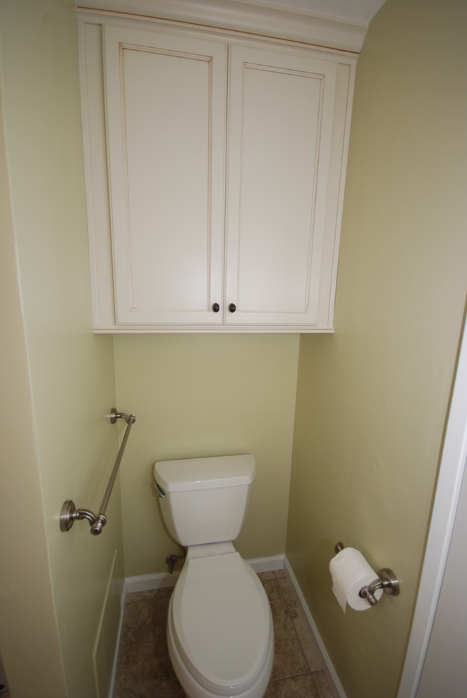 This is an example of a traditional powder room in Other with an undermount sink, flat-panel cabinets, white cabinets, granite benchtops, a two-piece toilet, beige tile and porcelain tile.