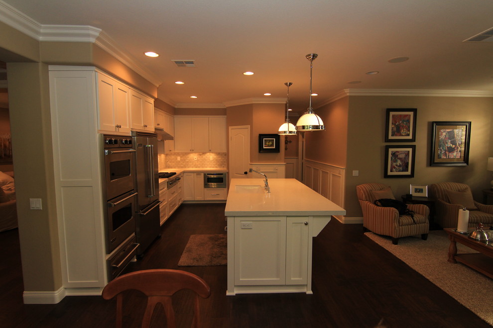 Example of a transitional l-shaped eat-in kitchen design in Orange County with an undermount sink, shaker cabinets, white cabinets, quartz countertops and stainless steel appliances