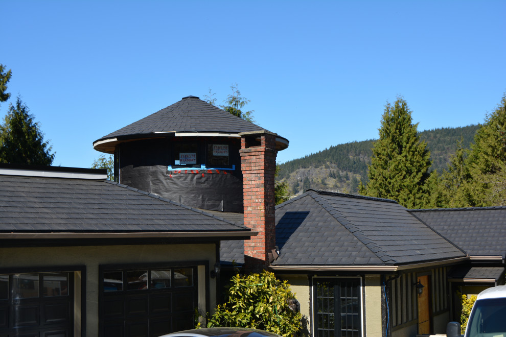 Idée de décoration pour une grande façade de maison beige victorienne à niveaux décalés avec un toit à deux pans, un toit en shingle et un toit noir.