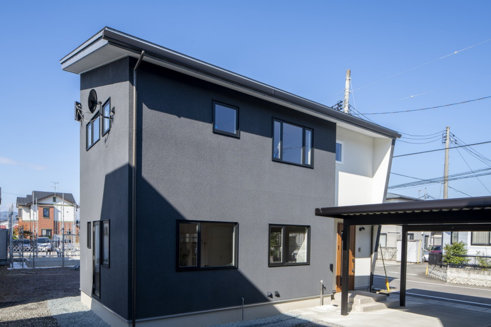 Стильный дизайн: двухэтажный, черный частный загородный дом среднего размера в стиле модернизм с комбинированной облицовкой, односкатной крышей, металлической крышей и черной крышей - последний тренд