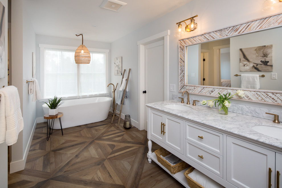 Design ideas for a large country master bathroom in San Francisco with flat-panel cabinets, white cabinets, a freestanding tub, a corner shower, a one-piece toilet, white tile, marble, white walls, porcelain floors, an integrated sink, marble benchtops, brown floor and a hinged shower door.