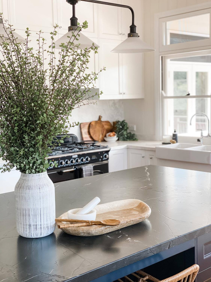 Photo of a transitional eat-in kitchen in Brisbane with a farmhouse sink, shaker cabinets, blue cabinets, soapstone benchtops, white splashback, marble splashback, medium hardwood floors, with island and grey benchtop.