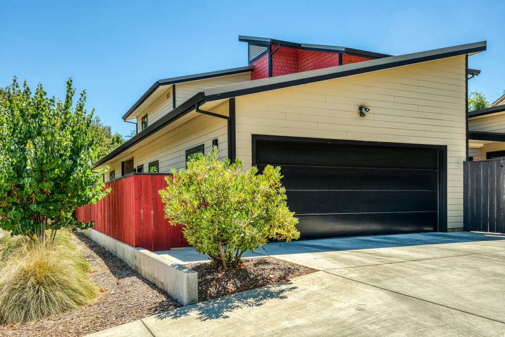 Large and multi-coloured contemporary two floor detached house in Sacramento with concrete fibreboard cladding, a lean-to roof, a metal roof, a grey roof and shiplap cladding.
