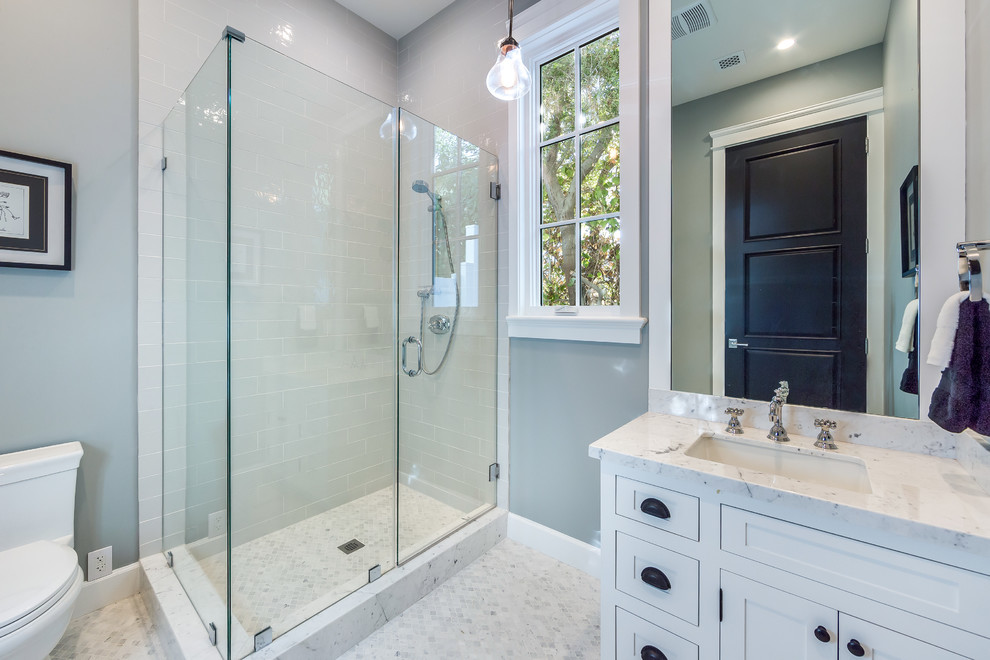 Inspiration for a small transitional 3/4 bathroom in Los Angeles with shaker cabinets, white cabinets, an alcove shower, a one-piece toilet, white tile, glass tile, white walls, mosaic tile floors, a drop-in sink, marble benchtops, white floor, a hinged shower door, white benchtops and a freestanding tub.