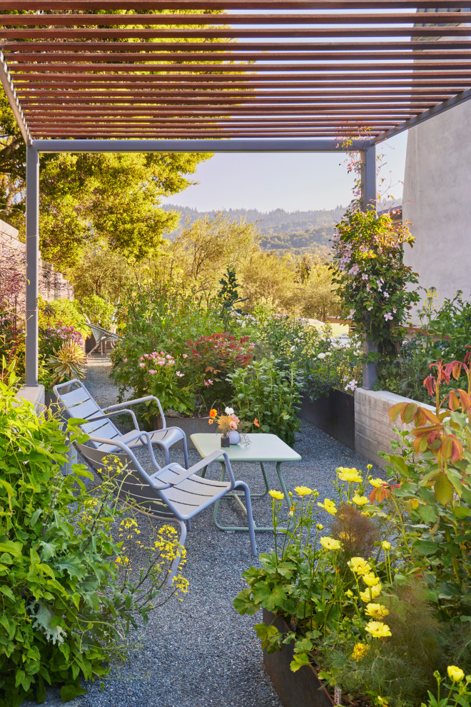 This is an example of a mid-sized contemporary side yard gravel and wood fence landscaping in San Francisco with a pergola.