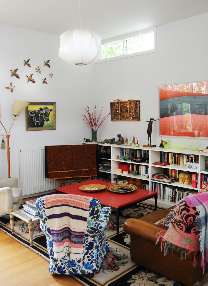 Inspiration for a small eclectic living room in Sydney with a library, white walls and light hardwood floors.