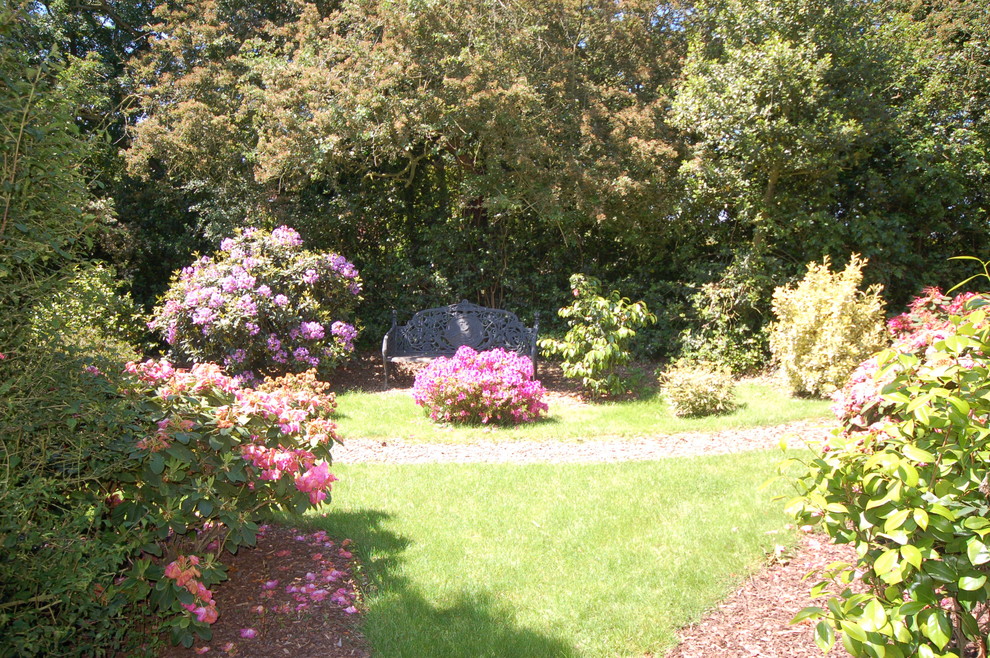 Photo of a large traditional backyard garden in Essex with a garden path and mulch.
