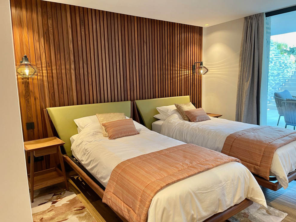 На фото: большая гостевая спальня (комната для гостей) в стиле модернизм с белыми стенами, полом из керамогранита, многоуровневым потолком, деревянными стенами и акцентной стеной