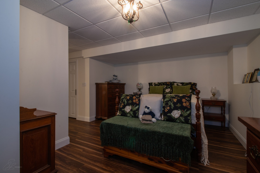 Стильный дизайн: хозяйская спальня среднего размера в классическом стиле с белыми стенами, полом из ламината, стандартным камином, фасадом камина из плитки и коричневым полом - последний тренд
