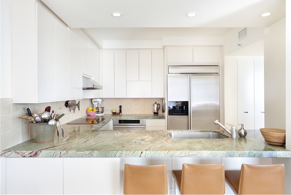 Inspiration for a contemporary u-shaped kitchen in Miami with an undermount sink, flat-panel cabinets, white cabinets, beige splashback, stainless steel appliances, no island and green benchtop.