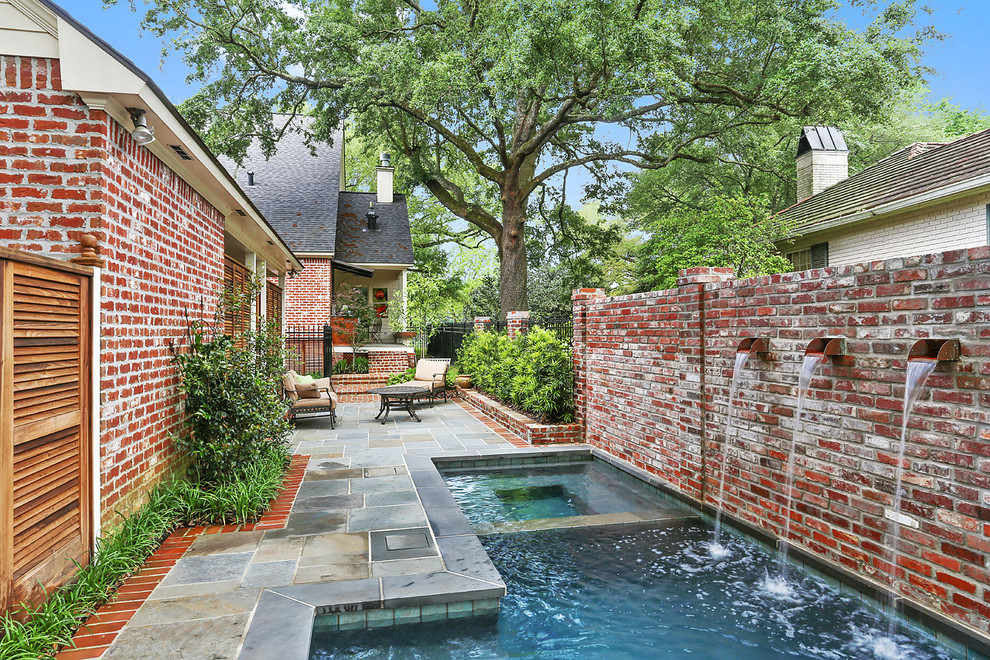 Inspiration for a small transitional courtyard custom-shaped natural pool in New Orleans with a hot tub and natural stone pavers.
