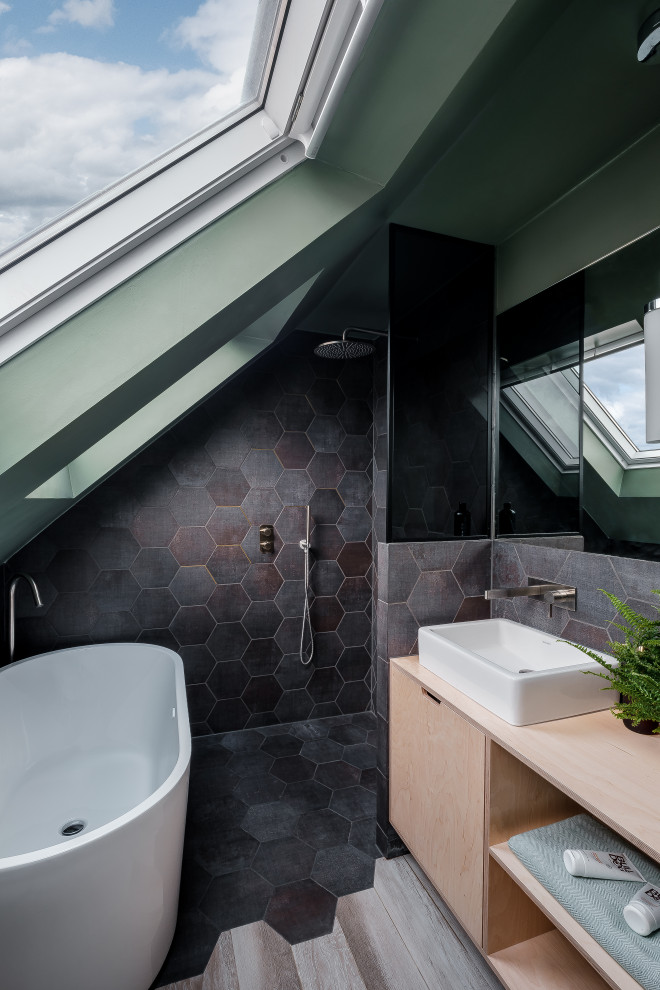 Пример оригинального дизайна: маленькая главная ванная комната в современном стиле с плоскими фасадами, светлыми деревянными фасадами, отдельно стоящей ванной, открытым душем, инсталляцией, черной плиткой, керамогранитной плиткой, зелеными стенами, настольной раковиной, столешницей из дерева, черным полом, открытым душем, бежевой столешницей, акцентной стеной, тумбой под одну раковину, подвесной тумбой, сводчатым потолком и полом из плитки под дерево для на участке и в саду