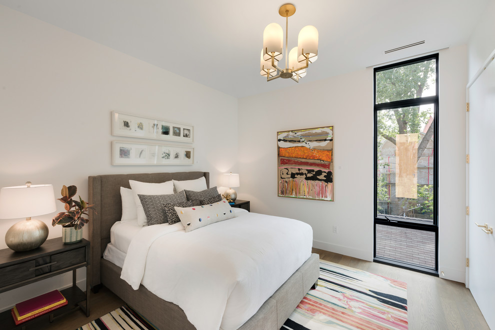 Mid-sized contemporary guest bedroom in Minneapolis with white walls, medium hardwood floors and brown floor.