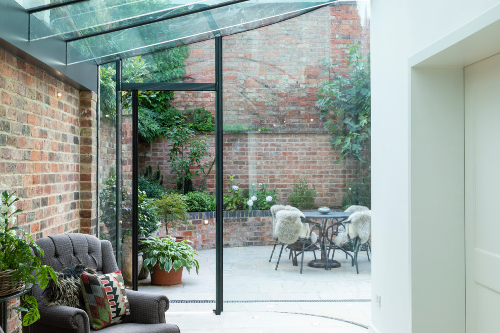 Design ideas for a medium sized modern conservatory in Gloucestershire with terracotta flooring and a glass ceiling.