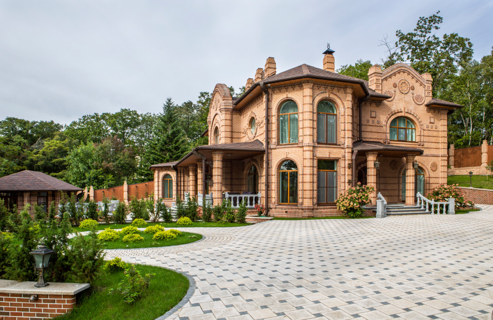 Стильный дизайн: двухэтажный, кирпичный, коричневый частный загородный дом в классическом стиле с коричневой крышей - последний тренд