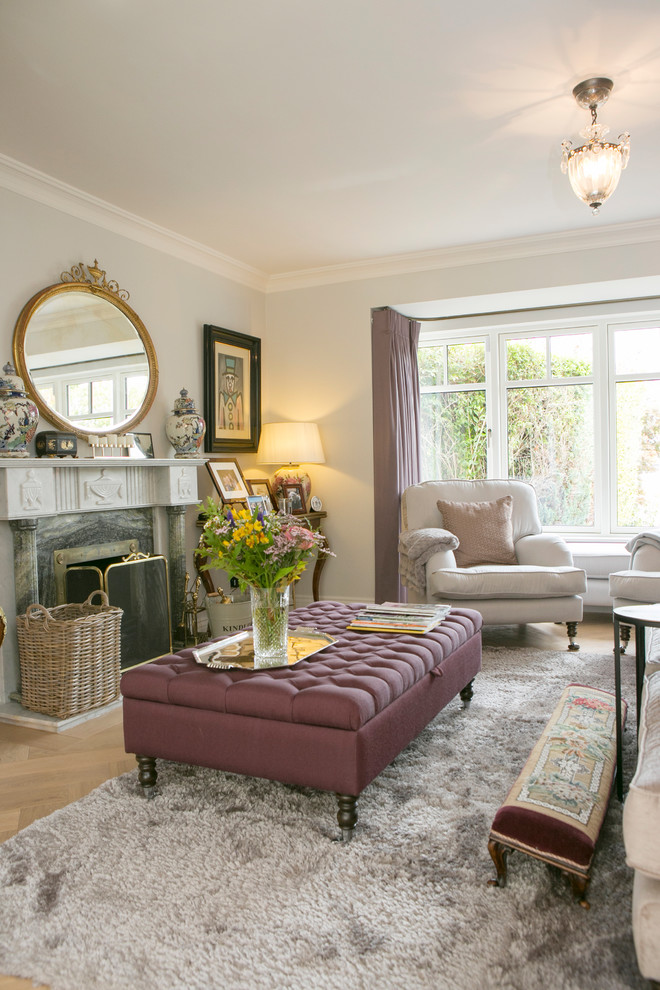 Design ideas for a traditional formal living room in Dorset with grey walls, light hardwood floors, a standard fireplace, a stone fireplace surround and beige floor.