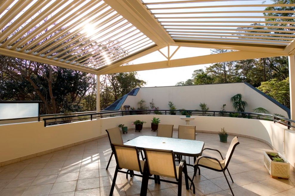 Photo of a contemporary courtyard patio in Sydney with tile and a pergola.