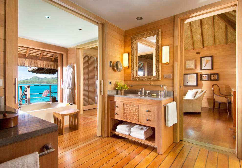 Photo of a tropical master bathroom in San Francisco with medium wood cabinets, medium hardwood floors and flat-panel cabinets.