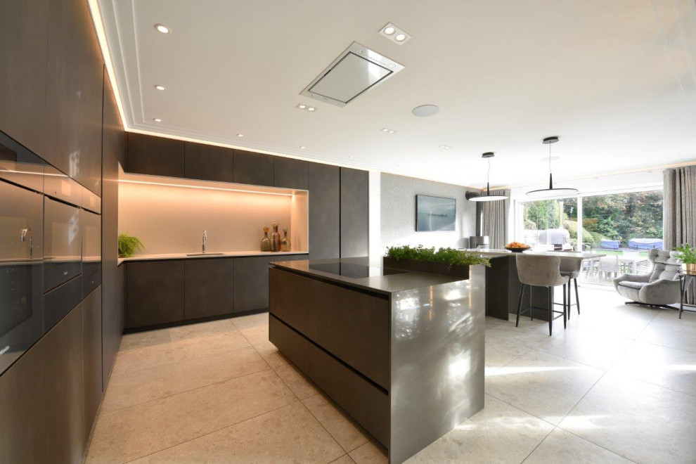 Large contemporary l-shaped open plan kitchen in Manchester with an undermount sink, flat-panel cabinets, grey cabinets, quartzite benchtops, beige splashback, limestone splashback, coloured appliances, porcelain floors, with island, grey floor, grey benchtop and coffered.