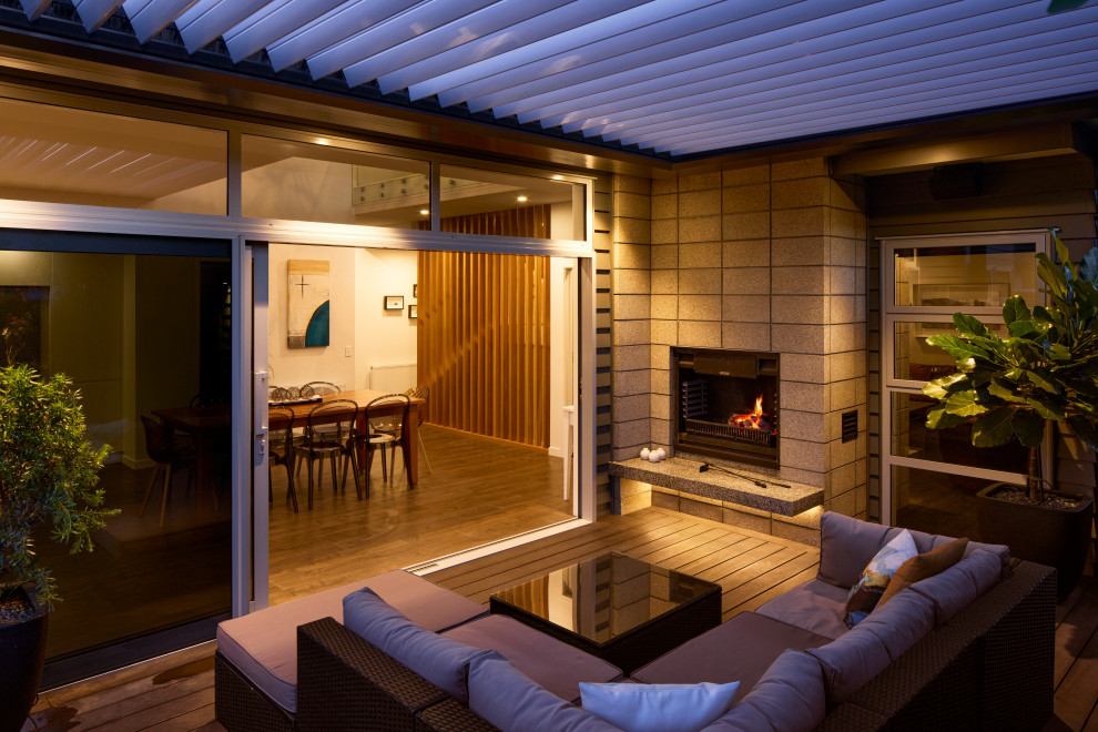 Inspiration for a Mid-sized contemporary Side Yard and Ground Level deck in Wellington With with Fireplace and a Pergola.