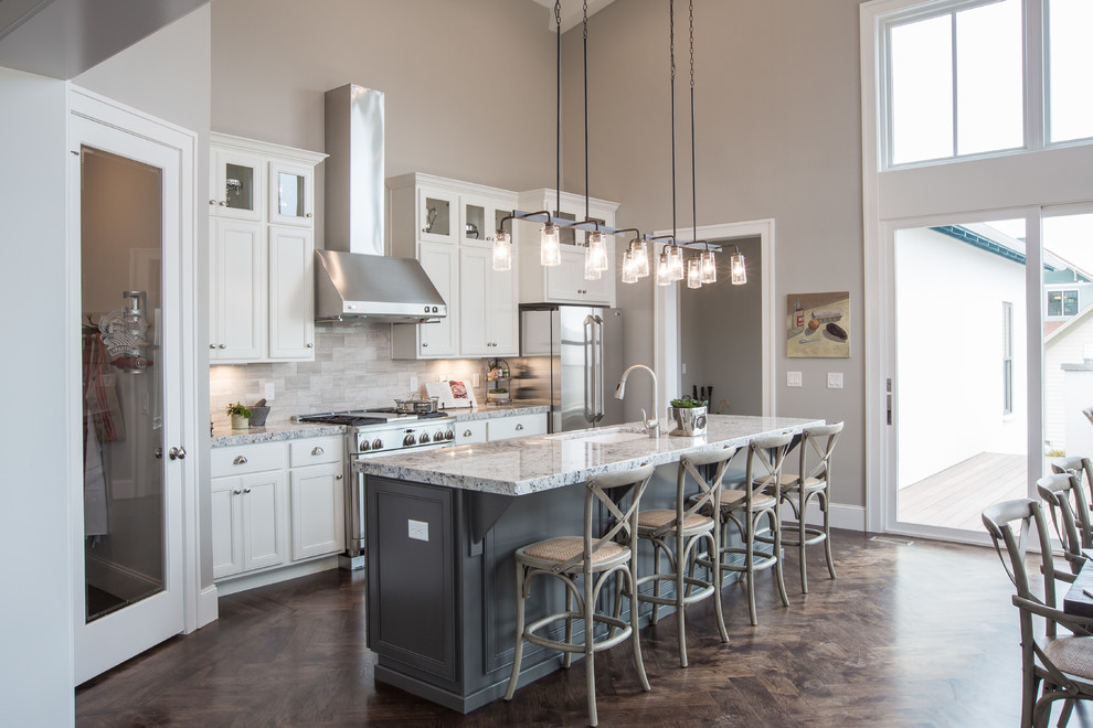 Traditional eat-in kitchen in Salt Lake City with an undermount sink, recessed-panel cabinets, white cabinets, grey splashback, stainless steel appliances, with island and limestone splashback.