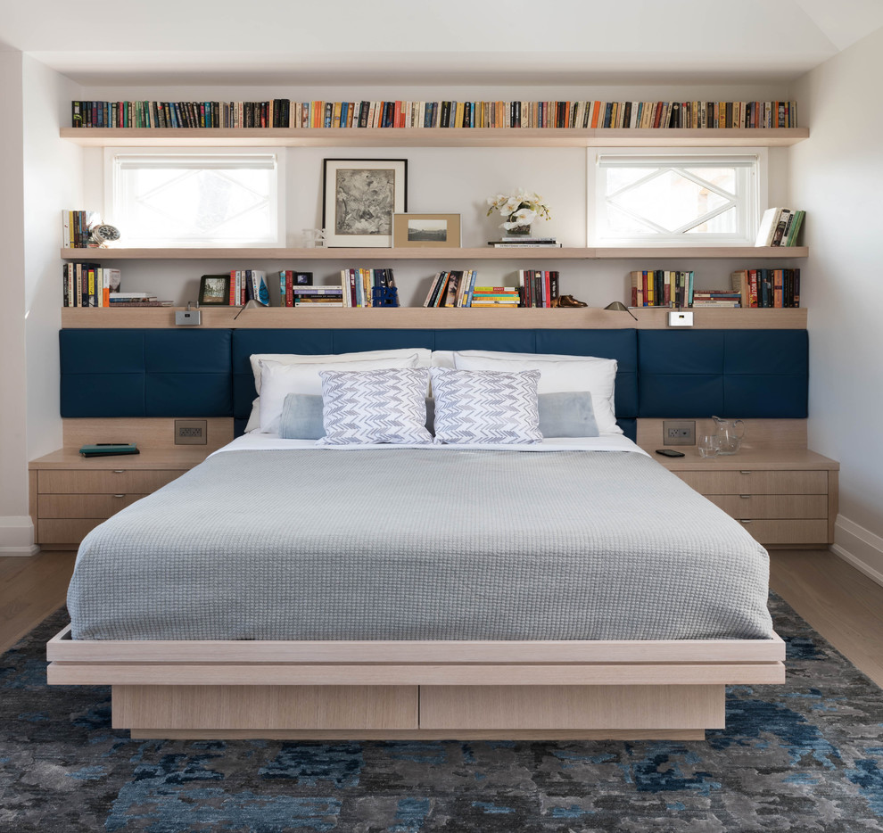 Inspiration for a contemporary light wood floor bedroom remodel in Toronto with white walls