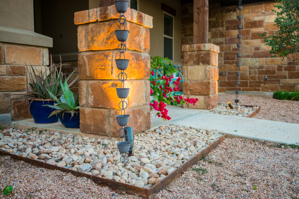 Photo of a medium sized classic front xeriscape full sun garden for summer in Austin with a desert look and decorative stones.